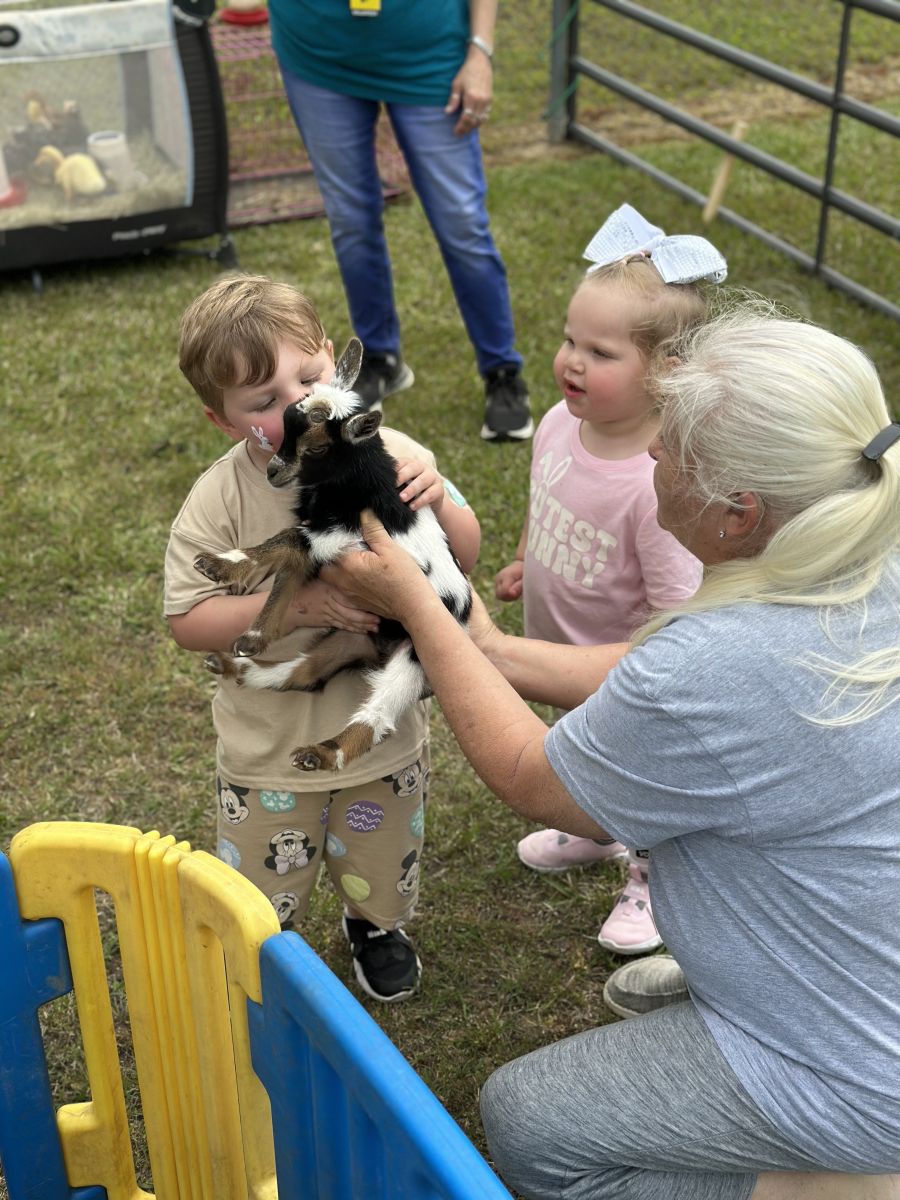 Kid giving a kid goat a kiss