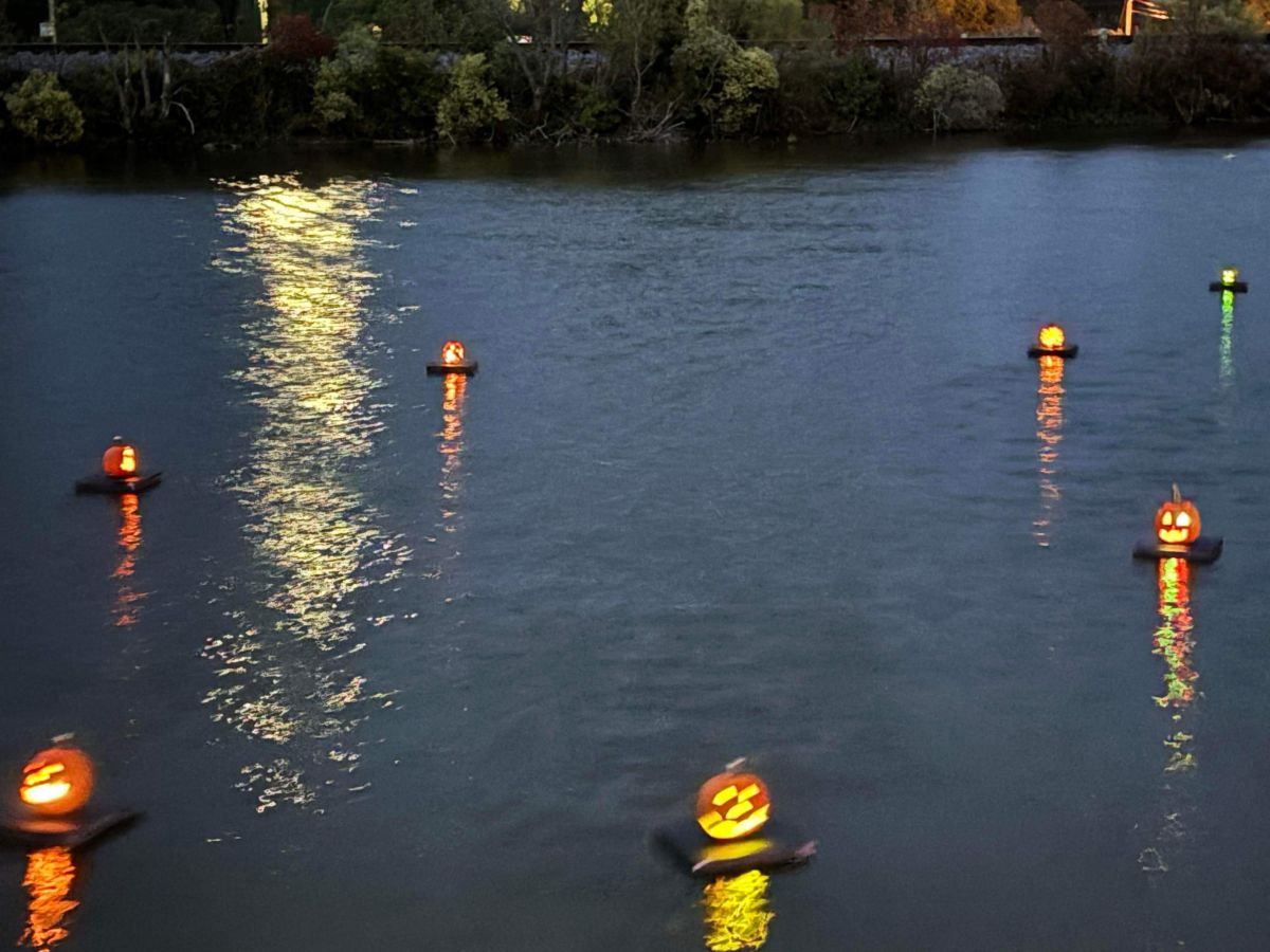 Pumpkins glowing and floating on the water.